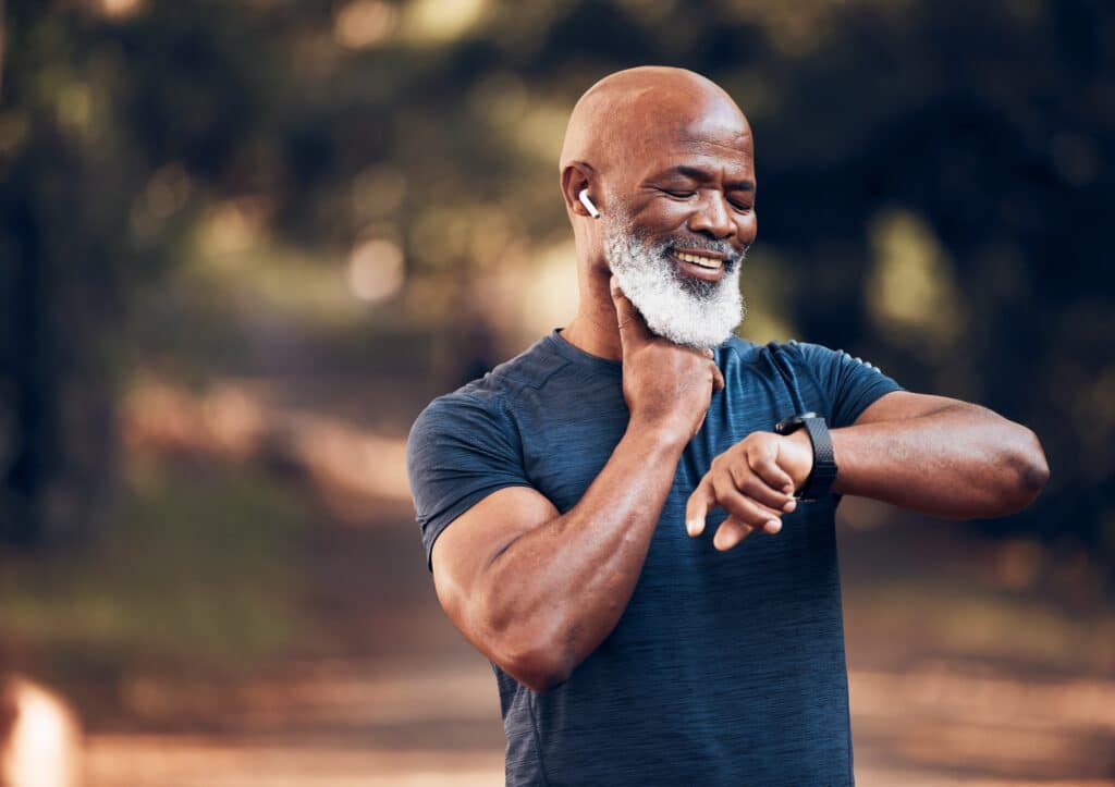 A middle aged African American man checking his pulse.