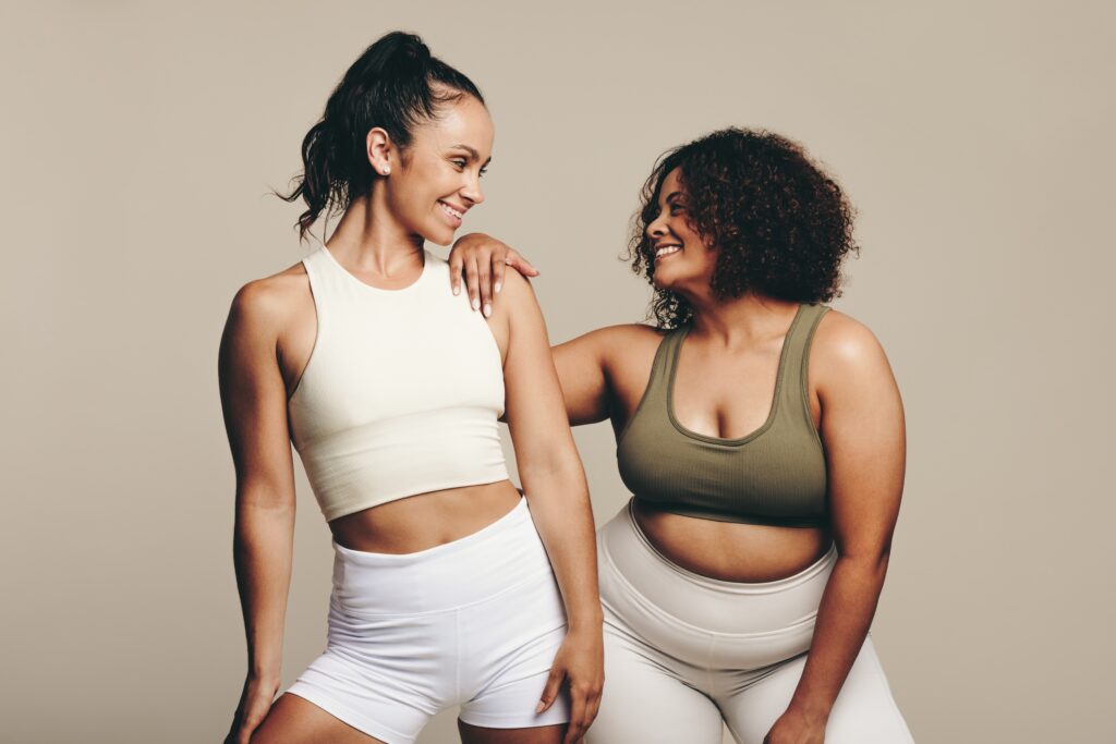 An image of two women looking at each other wearing workout clothes