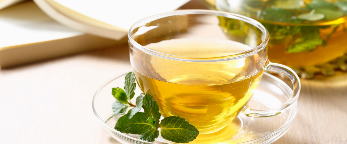 Cup of herbal mint tea on a table, promoting relaxation and natural support for a hormonally imbalanced body
