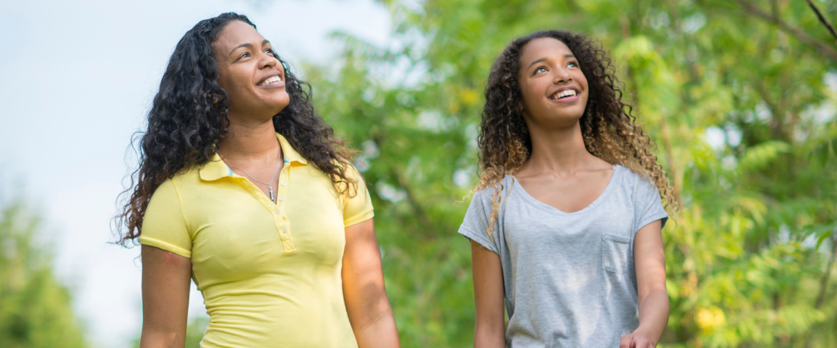 Two women enjoying a peaceful outdoor walk, supporting wellness and balance while managing hormonally imbalanced health