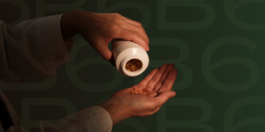 Woman tilting a bottle of vitamin b6 into hand to get out a tablet